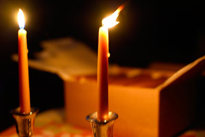 shabbat candles aflame in front of an open box